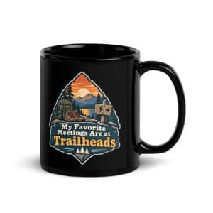 Nature and Adventure Black Coffee Mug: My Favorite Meetings Are at Trailheads, Scenic Shield Badge - 11 oz - Handle on Right