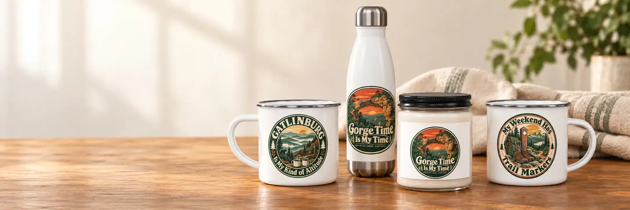Enamel camp mugs, a soy candle and a water bottle on a warm wooden table beside a window